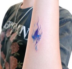 a woman's arm with a tattoo on it that has blue and purple ink