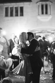 a man and woman kissing in front of a crowd