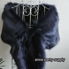 a blue fur coat hanging on a metal rack with clothes hangers attached to it