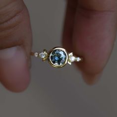 This unique design of modern boho 0.85c parti sapphire engagement ring is truly magical. Inspired by the moon shapes of its orbit cycle, it features a stunning round natural multi-colored parti sapphire captured in a raw bezel circle setting. The 14k yellow gold band is designed with two decorative side boho half moons and 4 side diamonds, making this beauty a one to remember! Perfect for the modern bohemian bride, this ring is sure to be a conversation starter. This ring is ready to ship in US 14k Gold Celestial Sapphire Ring, Celestial Yellow Gold Sapphire Ring, Celestial Sapphire Round Ring, Celestial Style Sapphire Ring For Anniversary, Celestial Style Round Sapphire Ring, Unique Sapphire Ring With Rose Cut Diamonds, Round Sapphire Fusion Ring, Fusion Style Sapphire Ring For Anniversary, Fusion Style Round Sapphire Ring For Anniversary