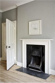 an empty room with a fireplace and pictures on the wall