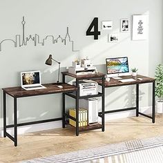 two desks in front of a wall with pictures on it and a lamp next to them