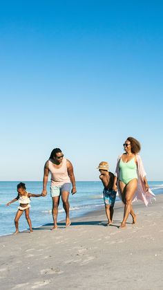 a family walking along the beach holding hands