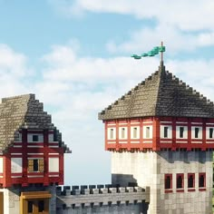 two buildings made out of legos sitting next to each other on top of a hill