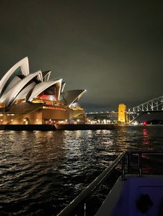 the sydney opera house is lit up at night