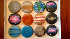 an open box with twelve painted rocks in the shape of planets and stars on them