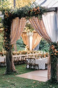 A charming fall garden wedding setup featuring plaid draped curtains and floral decorations, perfect for creating a rustic, outdoor wedding atmosphere. Rustic Outdoor, October Wedding, Rustic Wedding Decor