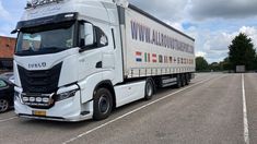 a white semi truck parked in a parking lot