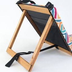 a folding chair that is made out of wood and has a colorful pattern on it