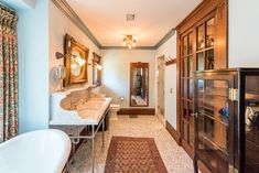 a bath room with a sink a mirror and a tub next to a window on the wall