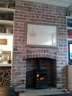 a fire place in a living room next to a book shelf