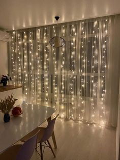 a dining room with lights on the curtains