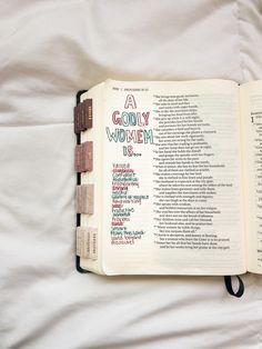 an open bible laying on top of a white sheet with words written in different languages