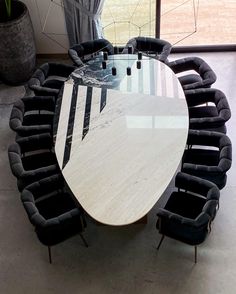 an oval table with black chairs around it