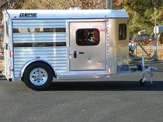 a white horse trailer parked in a parking lot