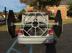 the back end of a car with two umbrellas attached to it's trunk