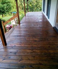 We love this stain that we used on our covered front porch, which is the length of our home. However, we are going to use the same on our side porch and back deck, which are not covered. It is absolutely beautiful! Primitive Exterior House, Dark Stain Porch, Dark Blue Houses, Green Siding, Solid Stain Colors