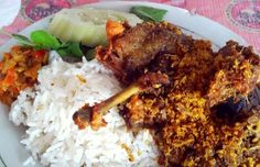 a white plate topped with rice and meat next to veggies on a table