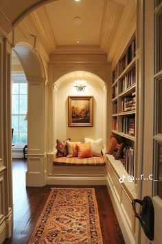 the hallway is decorated with bookshelves and rugs