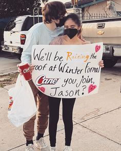 two people holding a sign that says, we'll be raising the roof at winter formal once you join jason