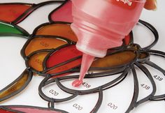 a close up of a bottle of paint on top of stained glass circles and numbers