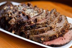 sliced meat sitting on top of a white plate