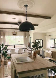 a kitchen and living room are shown in this image, with the light on above the sink