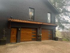 a black house with two brown garage doors