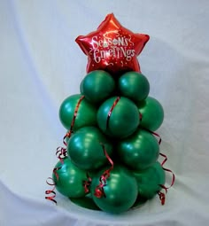 a christmas tree made out of green balloons with a red star on top that says merry christmas