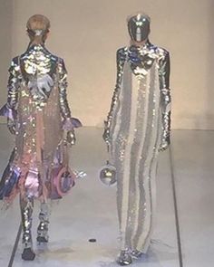 two mannequins dressed in shiny silver outfits