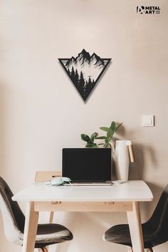 a laptop computer sitting on top of a white table next to two black leather chairs