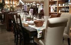 the dining room table is set with many chairs and place settings for two people to sit at