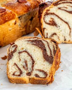 slices of cinnamon swirl bread sitting on top of a white marble counter next to a loaf of bread