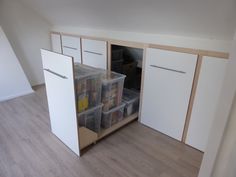 an empty room with white cabinets and drawers