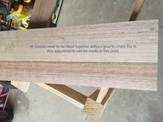 a piece of wood sitting on top of a table next to a wooden sign that says, all pieces need to be finished without glue to check it