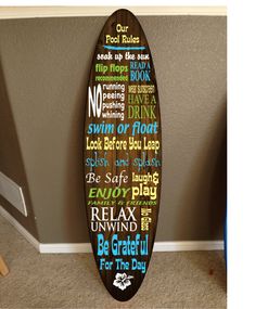 a surfboard with words written in different languages on it next to a wall hanging