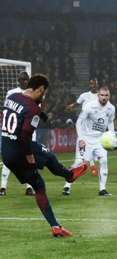 a soccer player kicks the ball during a game