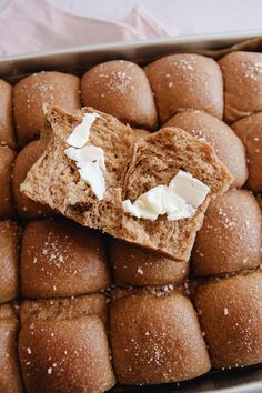 a tray filled with rolls covered in white icing and powdered sugar on top