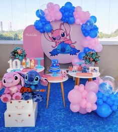 a birthday party with balloons, decorations and stuffed animals on the table in front of it