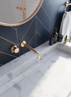 a white sink sitting under a mirror next to a faucet