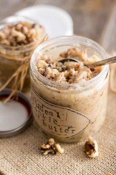 two jars filled with oatmeal sitting on top of a table next to a spoon