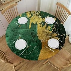 the table is set with white plates and place settings on it, along with two wooden chairs