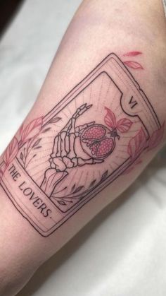 a person with a tattoo on their arm has a card in the shape of a heart