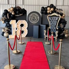 a red carpet is on the ground next to some chairs and poles with rope barriers around them