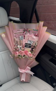 a bouquet of flowers in the back seat of a car with pink wrapping around it