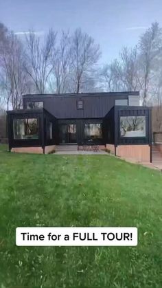 a black house sitting on top of a lush green field