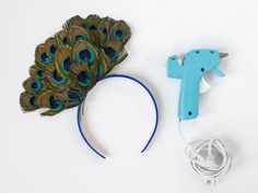 a hair dryer, headband and peacock feather on a white surface with wires