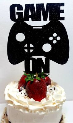 a cake that has some strawberries on top and a video game controller cut out of it