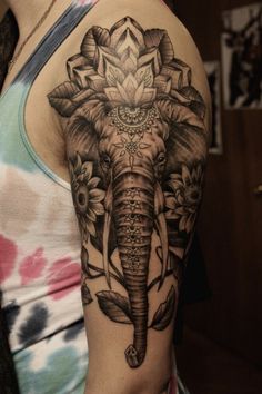 an elephant with flowers on it's back shoulder