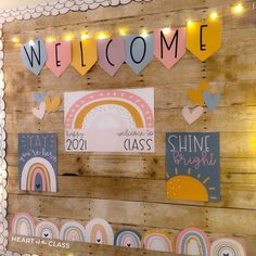 a wooden wall decorated with paper cutouts and string lights that spell out the word welcome